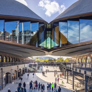 Stunning public space with a central open area surrounded by arches and a glass facade.