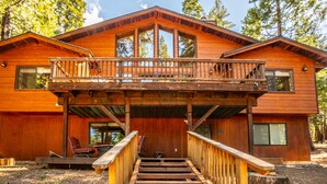 A wooden cabin with a balcony, a staircase leading to the entrance, and a chair outside. - Millville Chalet ~ Pool Access! (Camp Connell)