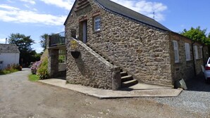 A stone building with a staircase leading to the entrance.