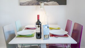 Et spisebord med en vinflaske, et glas og en pose chips.