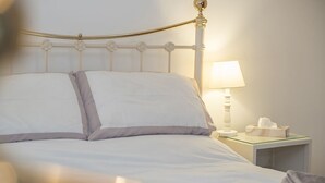 A neatly made bed with white bedding and a single bedside table with a lamp and tissues. - 15 Newport Road, Holiday Cottage Fishguard, Sleeps 5, 3 bedrooms,  bathrooms (FISHGUARD)