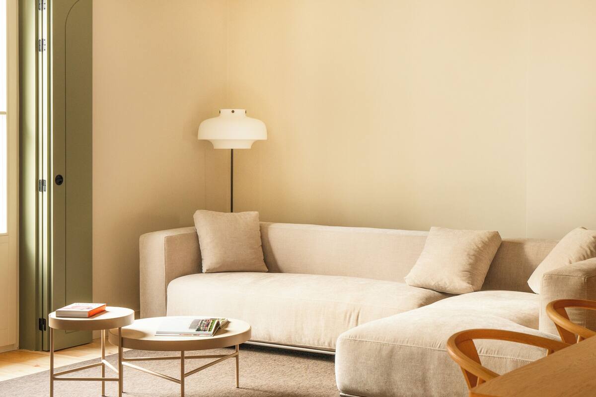 A modern living room with a sofa, a coffee table, and a lamp.
