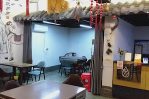 Ein Restaurantinneres mit einem Essbereich, einer Theke und einer Wand mit einem Wandgemälde.