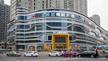 A multi-story commercial building with a curved facade, featuring prominent signage for 'Huawei' and 'Lande Mall'.