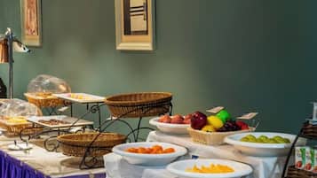 A buffet table with various food items and baskets.