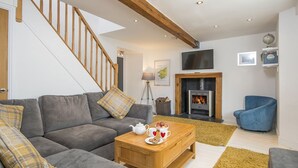 A living room with a sofa, coffee table, and a fireplace. - 7 Prendergast, Holiday Cottage Solva , Sleeps 6, 4 bedrooms,  bathrooms (Haverfordwest)