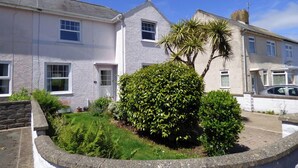 A row of white terraced houses with a well-maintained garden in the foreground. - 8 Garn Ingli, Holiday Home Fishguard, Sleeps 5, 3 bedrooms,  bathrooms (Fishguard)