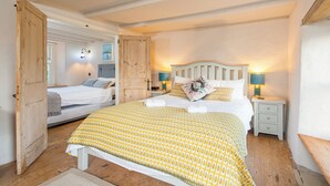 A bedroom with a bed, bedside tables, and a door leading to another room. - Alma Cottage, Holiday Cottage Solva, Sleeps 3, 2 bedrooms,  bathrooms (Haverfordwest)