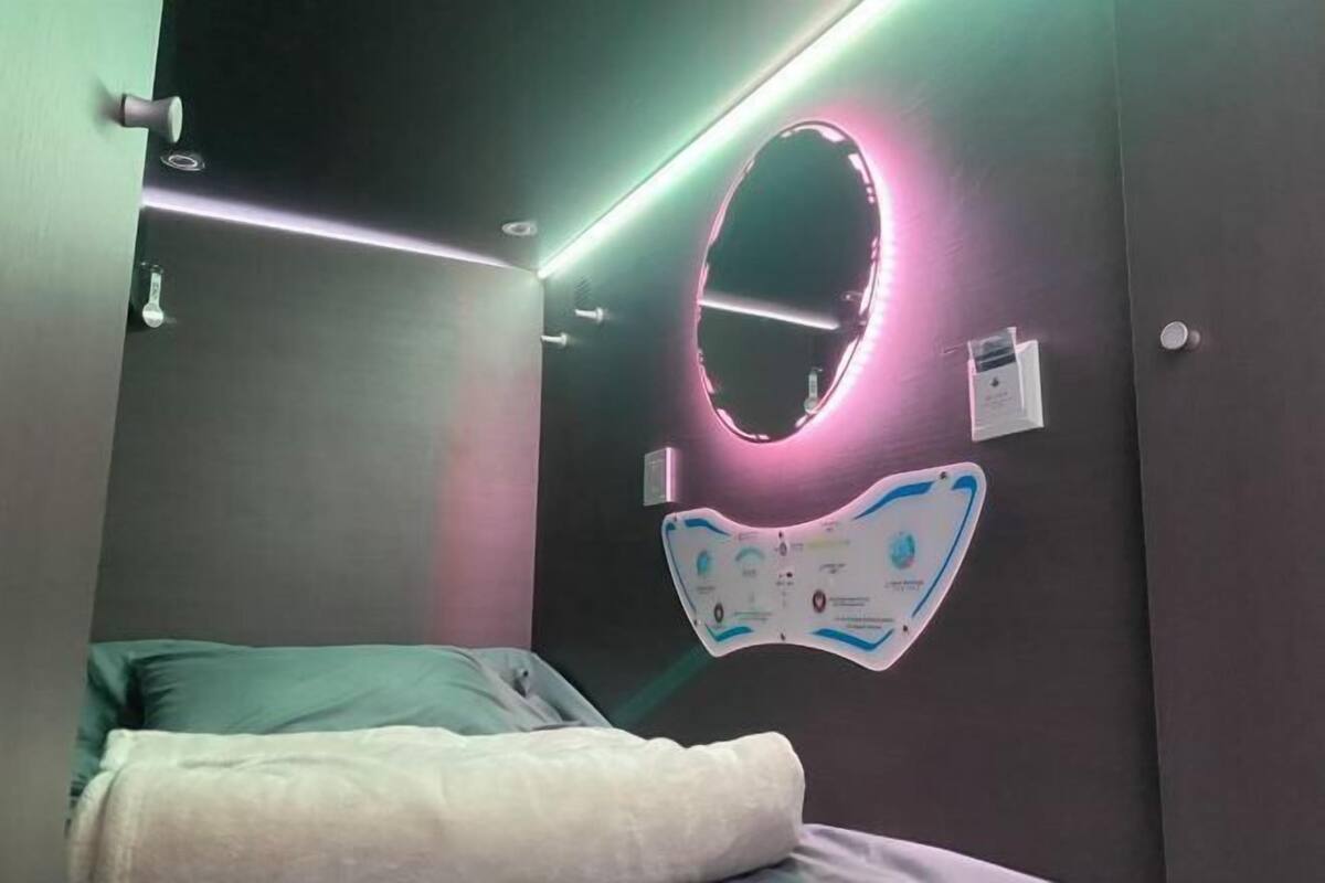 Een slaapkamer met een bed, een spiegel aan de muur en een wandkaart.