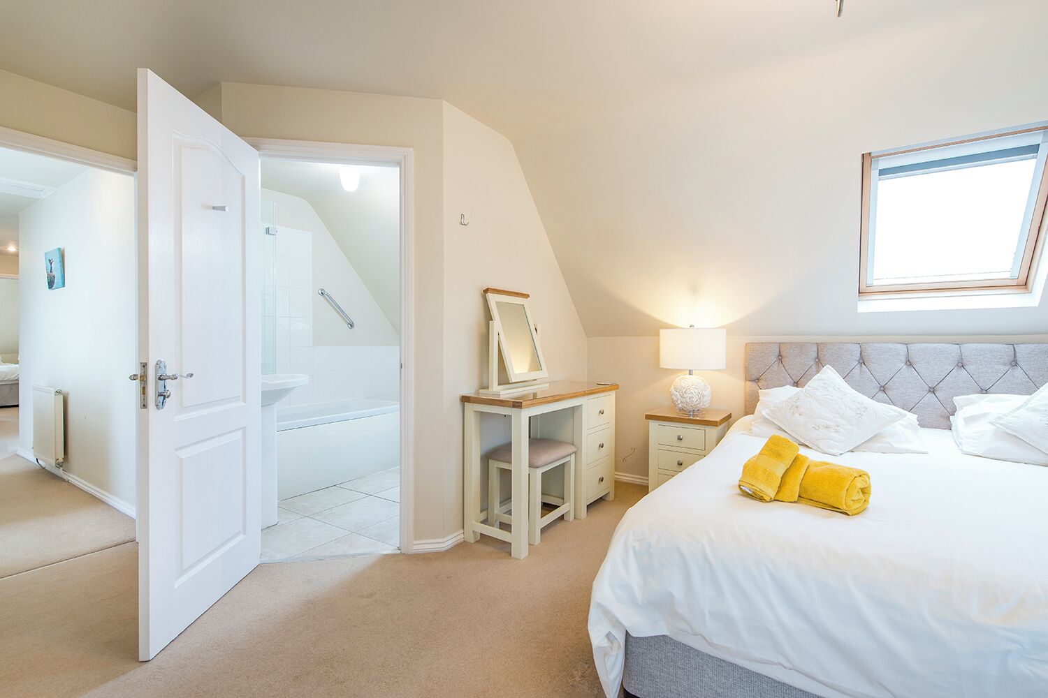 Een slaapkamer met een bed, nachtkastje en een raam.