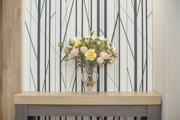 Una consola de madera con un florero de vidrio transparente.