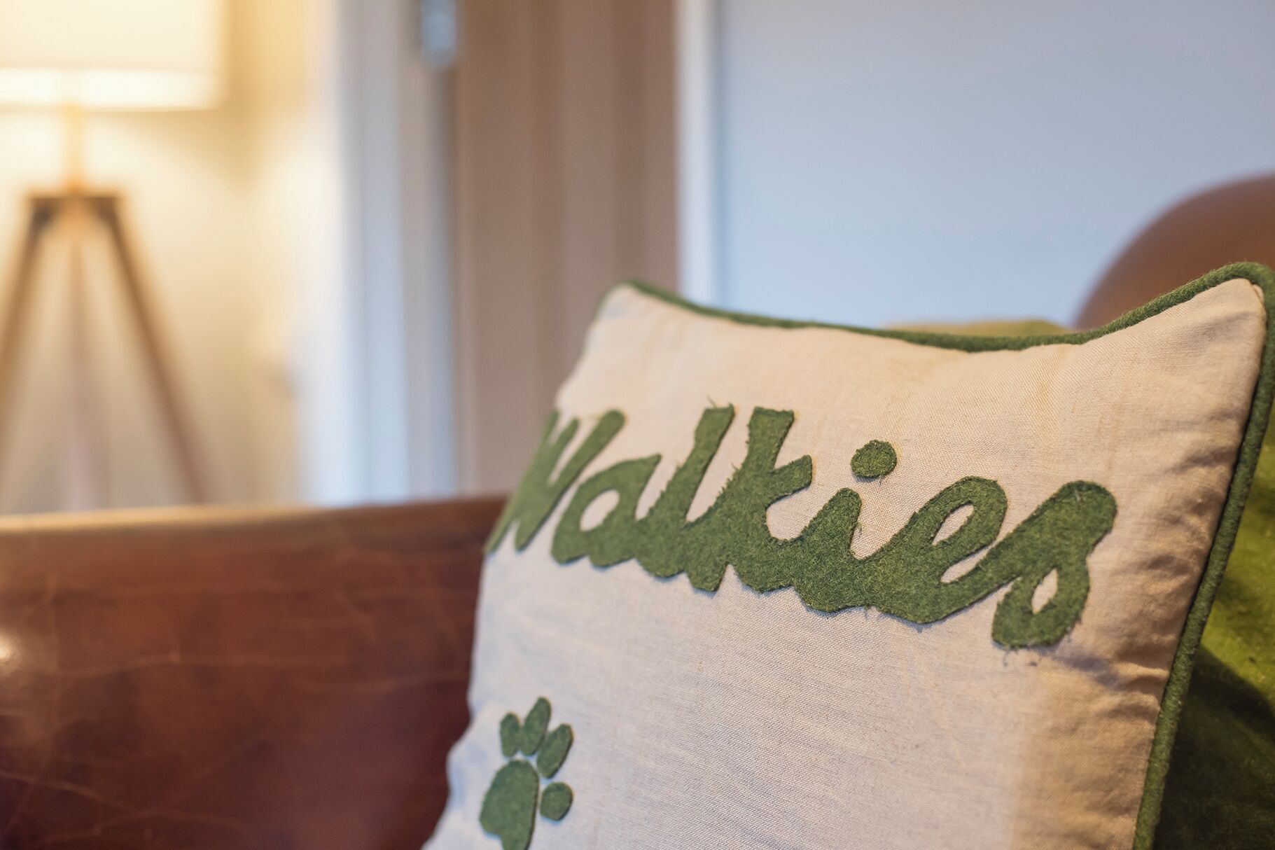 A pillow with the word "Walkies" embroidered on it.