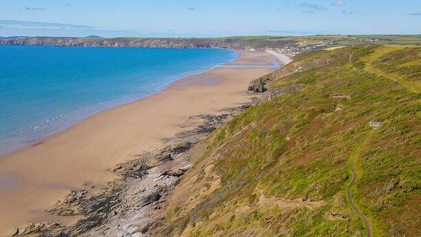 A coastal landscape with a sandy beach, grassy hills, and a clear blue sea. - Bwthyn Clyd, Holiday Cottage Keeston, Near Newgale, Sleeps 6, 3 bedrooms,  bathrooms (Haverfordwest)