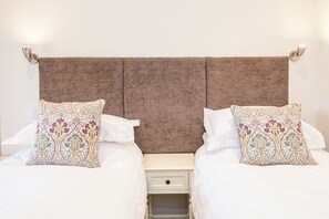 A double bed with a headboard, two decorative pillows, a bedside table, and a nightstand. - Carew Cottage, Holiday Cottage Carew, Sleeps 4, 2 bedrooms,  bathrooms (Tenby)