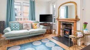 A living room with a sofa, television, fireplace, and a view of the outside. - Cherry Tree House, Holiday Cottage St Davids, Sleeps 5, 3 bedrooms,  bathrooms (Haverfordwest)