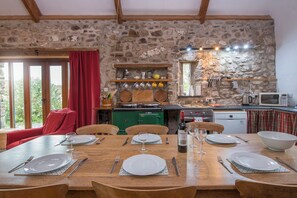 Enjoy a meal in this inviting dining area with a rustic backdrop, comfortable chair, and a view through the window.