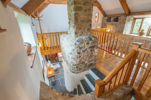 Cozy retreat with a stone fireplace, wooden staircase, and simple layout.