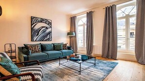 A modern living room with a sofa, coffee table, and artwork on the wall.
