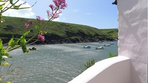 A coastal scene with boats on the water, greenery, and a white building. - Doves Cottage, Holiday Cottage Abercastle, Sleeps 2, 1 bedrooms,  bathrooms (Haverfordwest)
