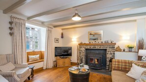 A cozy living room with a stone fireplace, wooden furniture, and a television. - Fairholme, Holiday Cottage Solva, Sleeps 4, 2 bedrooms,  bathrooms (Haverfordwest)