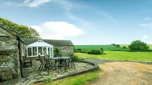 A stone building with a covered patio area featuring a table and chairs. - Felin Fach, Holiday property Llandeloy, Sleeps 8, 4 bedrooms,  bathrooms (Haverfordwest)