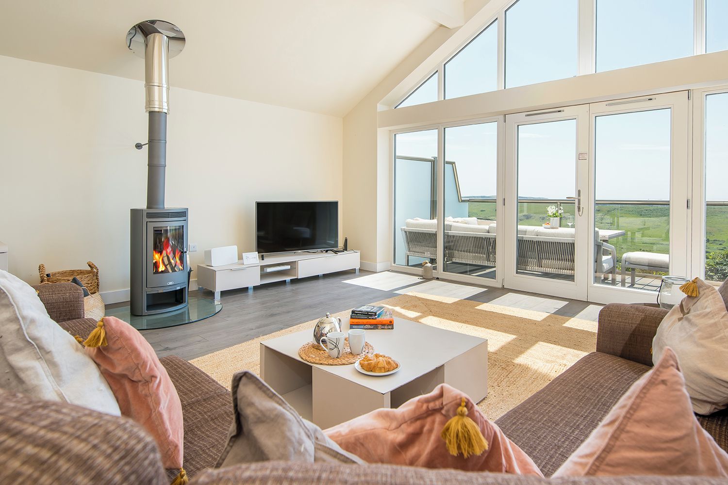 Uma sala de estar moderna com lareira, televisão de tela plana e uma grande janela com vista panorâmica.