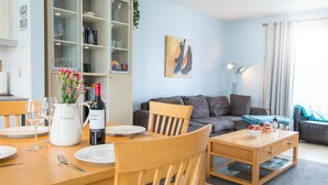 Un salon moderne comprenant un coin repas, un canapé et une bibliothèque.
