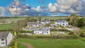 A residential area with houses, a driveway, and a large field in the background. - Green Plains, holiday home Wisemans Bridge, Sleeps 6, 3 bedrooms,  bathrooms (Narberth)