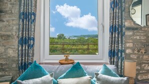 A room with a large window, a wooden stool, and a view of greenery and water. - Green Plains, holiday home Wisemans Bridge, Sleeps 6, 3 bedrooms,  bathrooms (Narberth)