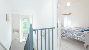 A bedroom with a bed, a desk, a window, and a staircase. - Greystones House, Holiday Home St Davids, Sleeps 6, 3 bedrooms,  bathrooms (Haverfordwest)
