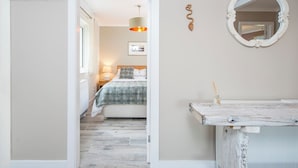 Une chambre à coucher avec un lit, une table de chevet et un miroir.