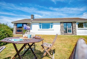 A house with a garden, a table with a book, a teapot, and a chair. - Hafod, Holiday Home Broad Haven, Sleeps 4, 2 bedrooms, bathrooms (Broad Haven)