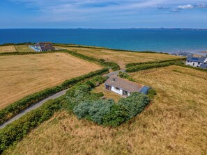 A coastal property with a house surrounded by fields, a path leading to the sea, and a distant view of the ocean. - Hafod, Holiday Home Broad Haven, Sleeps 4, 2 bedrooms, bathrooms (Broad Haven)