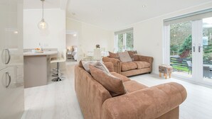 Ein modernes Wohnzimmer mit Sofa, Essbereich und Küche.