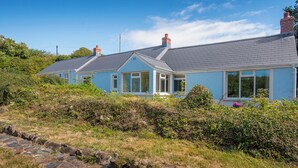 A coastal house with a grey tiled roof, white-framed windows, and a brick chimney. - Halfways, Holiday Home St Davids, Sleeps 8, 4 bedrooms,  bathrooms (HAVERFORDWEST)