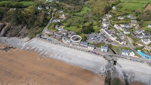 An aerial view of a coastal village with houses, a beach, and a circular structure. - Hazelbrook Cottage, Holiday Cottage Amroth, Sleeps 4, 2 bedrooms,  bathrooms (Amroth)