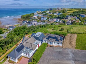 An aerial view of a coastal residential area with houses, a beach, and a cliff. - Heddfan Cottage, Holiday Home Little Haven, Sleeps 4, 2 bedrooms,  bathrooms (Haverfordwest)