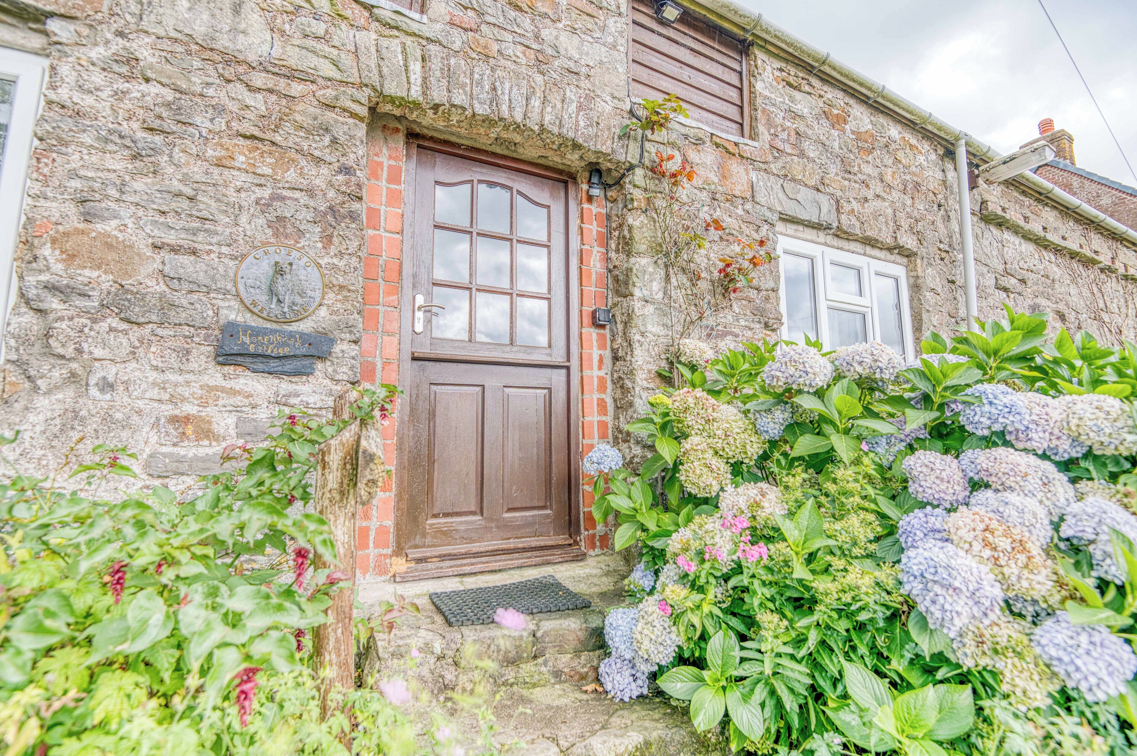 A stone building with a wooden door, a plaque, and a window.