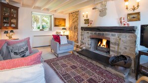 A cozy living room with a stone fireplace, a comfortable sofa, and a patterned rug. - Honeysuckle Cottage, Holiday Cottage Lochvane, Nr Solva, Sleeps 5, 2 bedrooms,  bathrooms (Solva)
