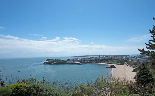 A coastal town with a sandy beach, a pier, and a church.