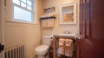 Un baño pequeño con inodoro, lavamanos y ventana.