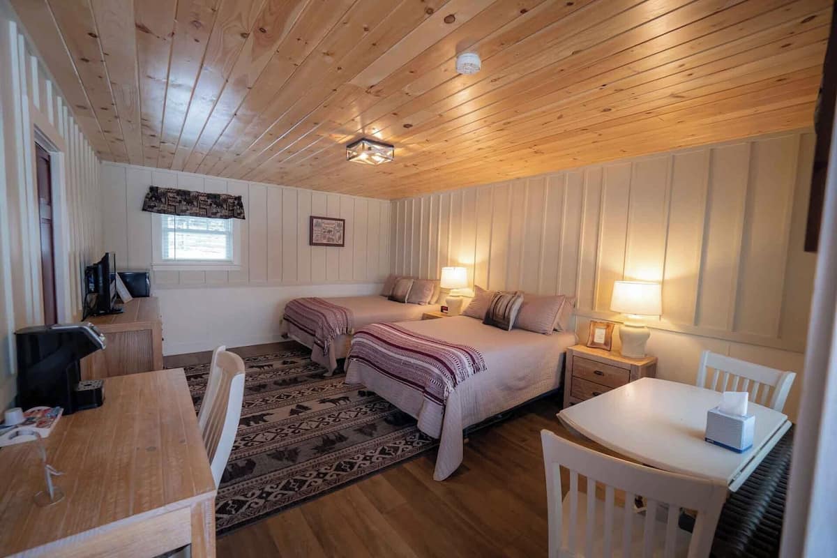 Een gezellige kamer met twee bedden, een bureau en een stoel.