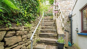 A stone staircase with metal handrails, leading to a building with a window and a door. - Ivy Cottage, Holiday Cottage Little Haven, Sleeps 5, 2 bedrooms,  bathrooms (Haverfordwest)