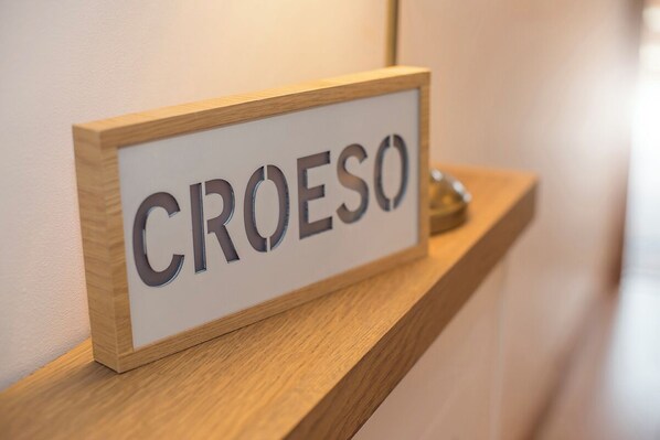 Un letrero de madera con la palabra 'CROESO' escrita en él.