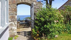 A stone archway leading to a staircase, surrounded by greenery and overlooking a body of water. - Little Pentower, Holiday Apartment Fishguard, Sleeps 2, 1 bedrooms,  bathrooms (Fishguard)