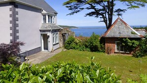 A coastal house with a stone archway, a grassy yard, and a view of the sea. - Little Pentower, Holiday Apartment Fishguard, Sleeps 2, 1 bedrooms,  bathrooms (Fishguard)