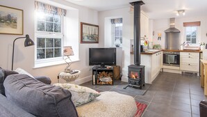 A cozy living room with a sofa, a television, and a fireplace.