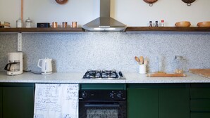 A kitchen with a gas stove, coffee maker, and a dishwasher. - Como Lake Panorama apartment Sveva with fireplace and private terrace (Cernobbio)