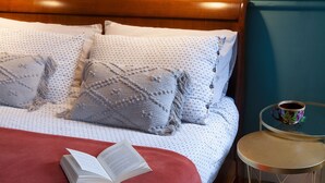 A neatly made bed with patterned pillows, a red blanket, and an open book on the bed. A small round table with a cup of coffee is beside the bed. - Como Lake Panorama apartment Sveva with fireplace and private terrace (Cernobbio)
