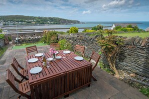 Enjoy a tranquil meal amidst lush gardens and a stunning coastal view.